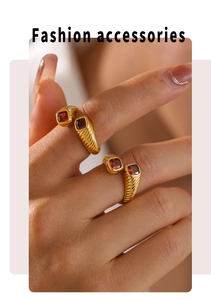 Detail of vintage gold open ring featuring a square red zircon on a model's finger