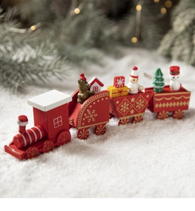 Detail of red wooden Christmas train set with cute dolls on artificial snow surface