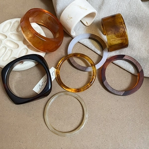 Detail shot of vintage iridescent resin bangles in amber and tortoiseshell patterns