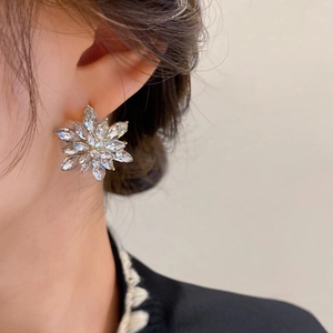 Close-up of elegant flower stud earring with marquise crystals on model's ear
