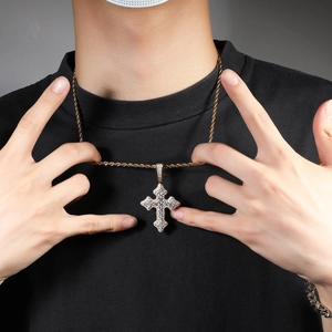 Gros plan du collier pendentif croix dorée avec pierres de zircon et chaîne torsadée