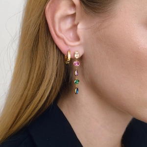Close-up of 18K gold-plated ribbed hoop earrings with colorful gemstones on a model