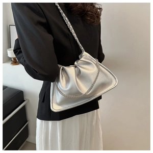 Detail shot of silver leather cloud bag featuring a shiny metallic finish and chain strap