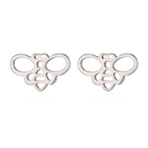 Détail macro de boucles d'oreilles abeille argentées en acier inoxydable poli