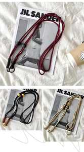 Detail view of woven adjustable shoulder straps in crimson, black, and beige colors