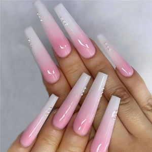 Close-up of long coffin-shaped pink and white gradient press-on nails with small rhinestones