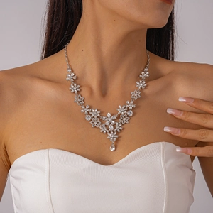 Detailed view of a silver flower necklace with sparkling zircons on a female model