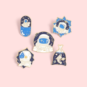 5-piece set of cartoon astronaut enamel pins with space designs in blue and gold finish