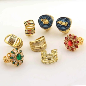 Detail of eight gold rings featuring colorful gemstones and intricate geometric designs