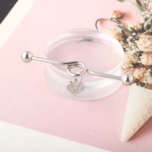 Detail of silver twisted industrial barbell with a sparkling diamond-set heart pendant