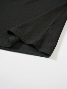 Gros plan sur le tissu gaufré noir montrant les détails de couture précise de l'ourlet
