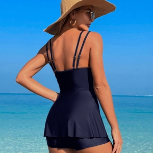 Rückansicht eines marineblauen zweiteiligen Badekleids mit Shorts an einem sonnigen Strand