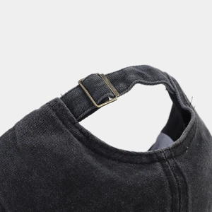 Détail de la boucle en laiton réglable sur la casquette de baseball grise délavée