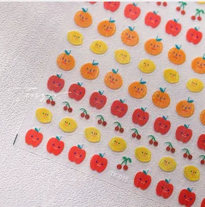 Close-up of cute fruit nail art stickers with smiling apple and cherry patterns