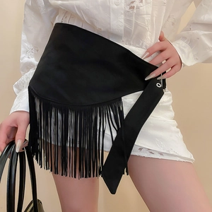 Detail of bohemian black fringe belt on a model showing tassel texture and drape
