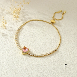 Detail of adjustable gold tennis bracelet with pink heart-shaped crystal and slider clasp