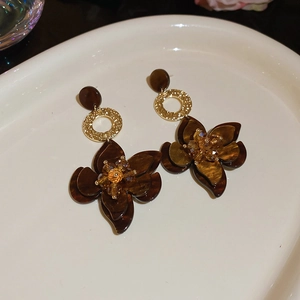 Detailaufnahme der Blumenohrringe mit Harzblütenblättern in Schildpatt-Optik und Goldakzenten