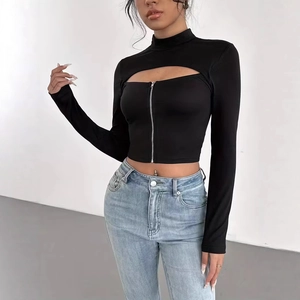 Détail d'un crop top noir ajouré avec col montant et fermeture éclair en métal devant