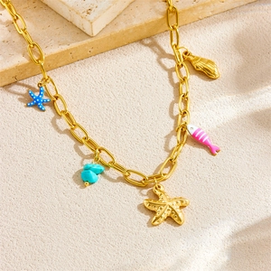 Goldene Halskette mit Seestern Fisch und Türkis Anhängern auf sandigem Hintergrund Design