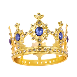 Macro detail of golden crown with blue oval gemstones and sparkling crystals on white background