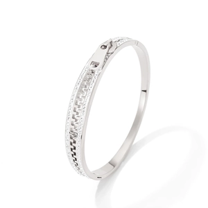 Silver zipper-shaped stainless steel bangle with pavé crystals in a luxury modern style
