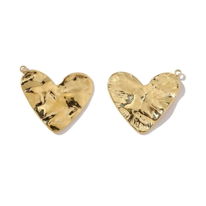 Vue détaillée de pendentifs coeur dorés avec texture en métal martelé pour bijoux