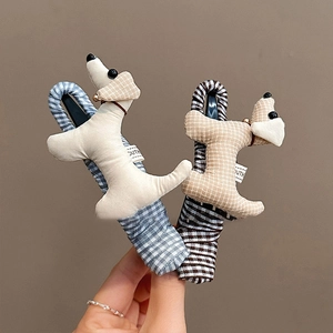 Barrette chiot en peluche avec clochettes en crème et carreaux tenue à la main