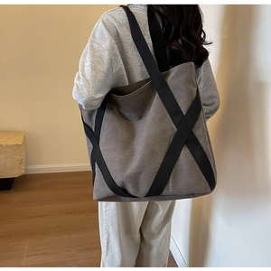 Canvas tote bag showing the reinforced bottom structure and black woven straps