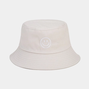 Détail de la broderie smiley sur un chapeau bob en coton beige avec bord surpiqué