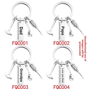 Detail of metal Dad tool keychain set featuring miniature hammer and engraved gift tag
