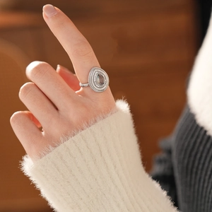 Gros plan d'une bague goutte en argent avec zircons et pierre de lune sur une main