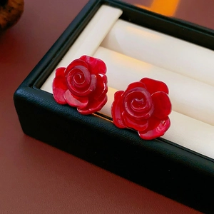 Vue macro des boucles d'oreilles roses en résine rouge vif avec tige en argent