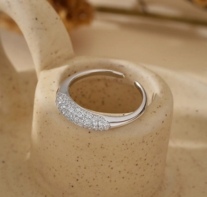 Macro shot of silver adjustable ring with pavé-set zircons on ceramic holder