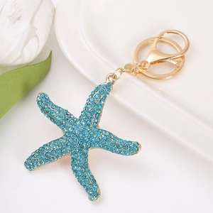 Close-up of golden starfish keychain with sparkling blue rhinestones and spring clasp