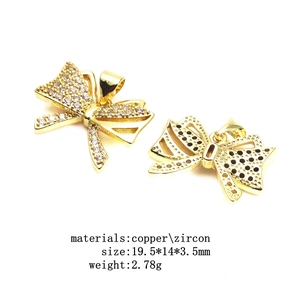 Macro detail of a gold bow pendant featuring inlaid zircon and polished copper finish