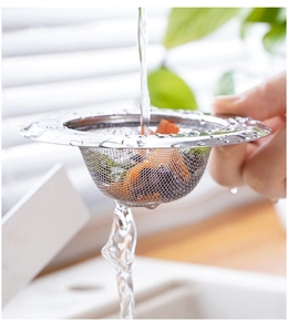 Macro shot of stainless steel kitchen sink strainer filtering food waste under running water
