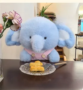 Close-up of soft plush elephant toy wearing pink corduroy overalls with button detail