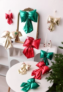 Metallic red and gold Christmas bows hanging on a wall as elegant holiday decor