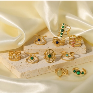 Detail of vintage 18k gold plated stainless steel rings with colorful emerald stones