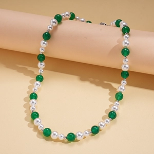 Detail of three-piece beaded necklace featuring white pearls and green agate beads