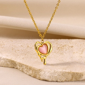 Detail of a pink cat eye stone heart pendant with a gold fluid melt frame