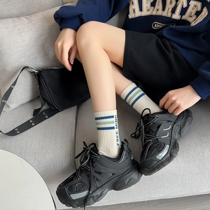 Détail de chaussettes en coton blanc avec texte FREE MIND et baskets noires