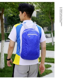 Rear view of a model wearing a lightweight blue waterproof outdoor travel backpack in a park
