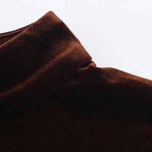 Gros plan sur l'encolure en dentelle délicate et la texture en velours marron foncé