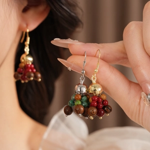 Detail of bohemian tassel earrings with wooden beads and colorful glass accents