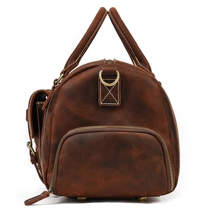 Close-up of leather travel bag detailing zipper pocket and metal protective feet