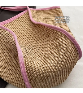 Detail of hand-woven straw bag texture with pink fabric trim and sturdy handle