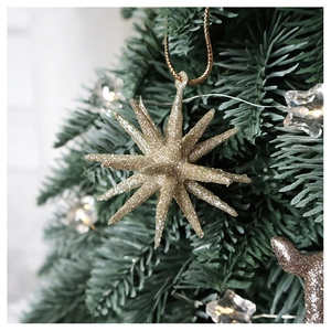 Detailed close-up of a glittery gold star hanging ornament on a festive Christmas tree branch