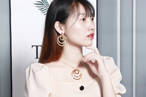 Close-up of a woman wearing the gold geometric interlocking circle necklace and earrings set