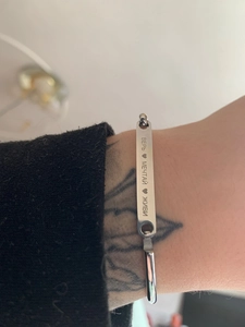 Close-up of engraved silver stainless steel cuff bracelet with Russian motivational text